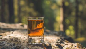 A vibrant pink Johnny Vegas Shot in a glass with a lime wedge garnish.